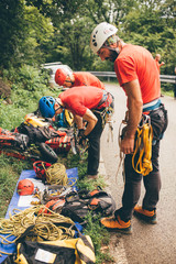 Male rescuer climbers with equipment preparing for action 
