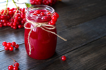Delicious  viburnum jam with fresh berries on dark wooden table.