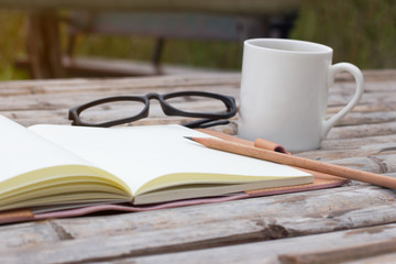 Mockup top view of notebook with pencil glass coffee cup on bamboo wood table.empty white space you can put your text.