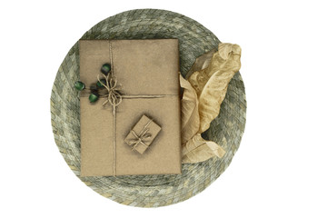 Composition of gift boxes wrapped in beige paper and bundled with ribbons. Decorated with young oak acorns and dry leaves