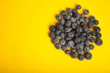 Heap of blueberries isolated on yellow colorful background. Summer vibe fruit berry with copy space. Ingredient for breakfast.