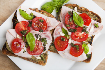 Healthy bread toast with pesto sauce, tomatoes, garlic and basil leaves. Delicious snack.