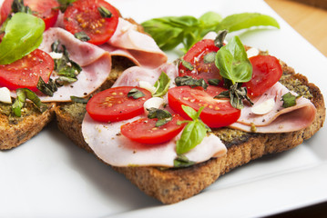 Fototapeta na wymiar Healthy bread toast with pesto sauce, tomatoes, garlic and basil leaves. Delicious snack.