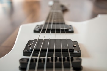 Fototapeta na wymiar Weiße Heavy E-Gitarre auf braunem Hintergrund