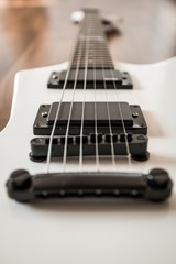 Fototapeta na wymiar Weiße Heavy E-Gitarre auf braunem Hintergrund