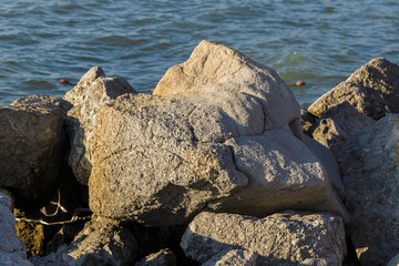 Sea waves are fighting against the big rocks on the shore.