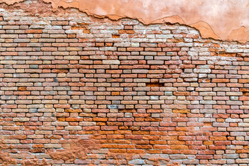Old and damaged orange brown brick wall