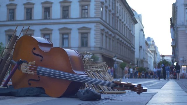 On ground double bass musical instrument left by a street musician.