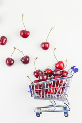 Ripe cherries in a shopping cart isolated