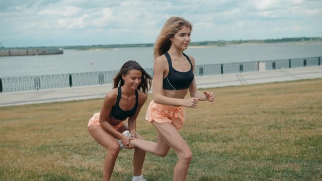 fitness, training, aerobics and people concept - group of girls working out with steppers stretching yoga on the beach in park city river female body, skinny sport happy woman team