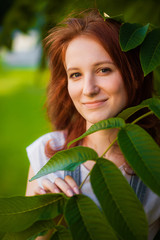 Vertical portrait of redhead girl smiling on green background