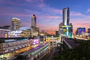 Fotobehang Cityscape view of Pratunam, famous shopping landmark in Bangkok, Thailand at sunset time and boat in river for transportation © kunchainub