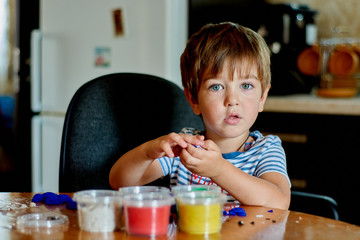 Close-up portrait of baby boy playing with kinetic sand