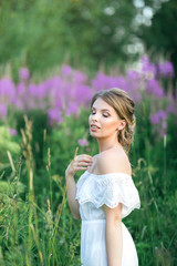 Beautiful young happy girl in the blossoming fields, thinking about her life and goals. Slow life, minimalism, mindfulness