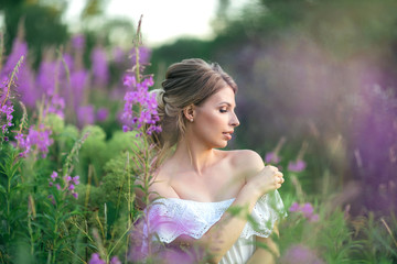 Beautiful young happy girl in the blossoming fields, thinking about her life and goals. Slow life, minimalism, mindfulness