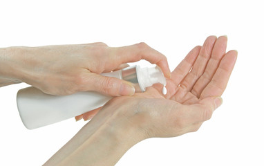 Gentle natural skin care for ageing skin - mature female hands dispensing hand cream into palm isolated on a white background 
