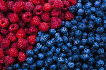 Blueberries and raspberries background. Top view.