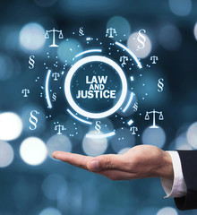 Hand holding Justice Scales and Paragraph symbols. Law and Justice concept