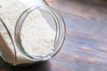 Rice croup in a jar on a dark wooden background.
