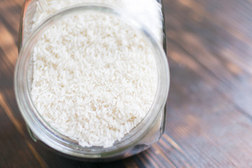 Rice croup in a jar on a dark wooden background.