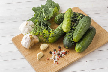 Marinated cucumbers, garlic and spices for salting on the wood surface.