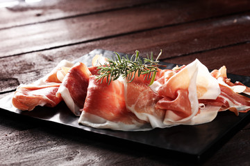 Italian prosciutto crudo or jamon with rosemary. Raw ham