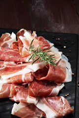Italian prosciutto crudo or jamon with rosemary. Raw ham