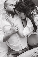 Couple in love pregnant lie in bed cuddling, waiting for baby
