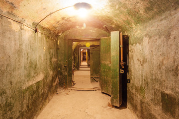 Dark corridor of old abandoned Soviet underground bunker, opened armored door