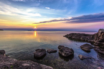 Fototapeta na wymiar Lake Superior Summer Sunset. Sunset over the rocky coast of remote Lake Superior in Copper Harbor, Michigan.