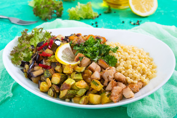 Delicious oriental salad tabbouleh. Couscous with fried vegetables and chicken on a white plate. Traditional Lebanese appetizer.
