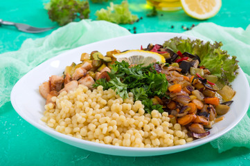 Delicious oriental salad tabbouleh. Couscous with fried vegetables and chicken on a white plate. Traditional Lebanese appetizer.