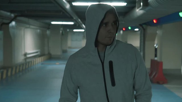Criminal man in a walks and looks menacingly at the camera.