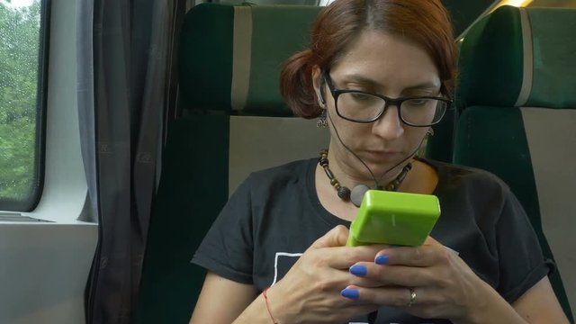 Girl playng game while travelling by train.
