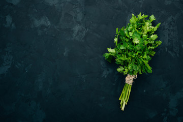 Fresh parsley. Organic food. On a black background. Top view. Free space for text.