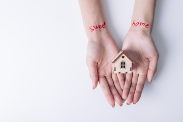 house in hands on a white background. Sweet home concept inscription
