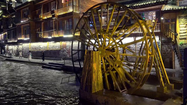 Water wheel on Tuojiang River of  Fenghuang Ancient Town at night. Xiangxi, Hunan, China