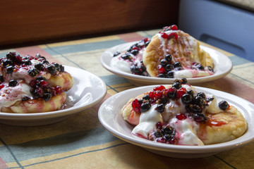 Homemade cheesecakes with sour cream and red and black currant sauce