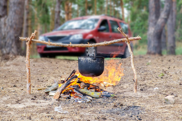 Smoked cauldron over a campfire in the forest. The concept of cooking in a hike