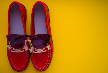 red moccasins with glasses on a yellow background