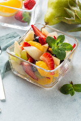 Bowl of fresh summer fruit salad on white stone background. Healthy food. 