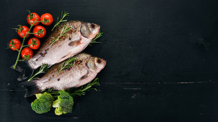 Raw Fish with Spices and Vegetables. Carp On a wooden background. Top view. Copy space.