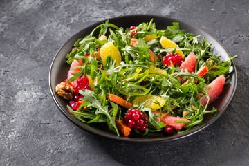 Fruit salad on black plate on dark background