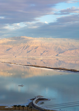 Sunset over lowest salty lake in world below sea level Dead sea, full of minerals near luxury vacation resort Ein Bokek, perfect place for medical treatments
