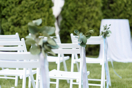 White chairs on a green lawn.