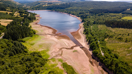 Aerial drone view of a drying reservoir in Wales during a heatwave (Llwyn-On Reservoir)