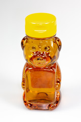 A bear shaped plastic bottle full of honey waiting to be used 