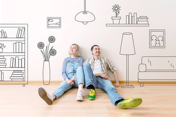 Photo of man and woman sitting on floor with painted on wall house flowers , paintings, sofa,...