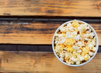 Popcorn in a glass on a wooden surface.