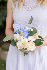 Stylish small bouquet in hands at the girl.
